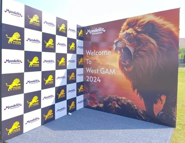 Event backdrop with a lion graphic and a checkered brand wall